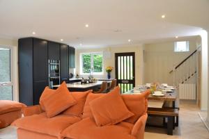 a living room with an orange couch and a table at Camellia in Falmouth