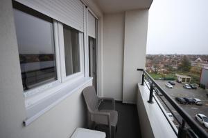 d'un balcon avec une chaise et une fenêtre. dans l'établissement Apartman Lux, à Nova Pazova