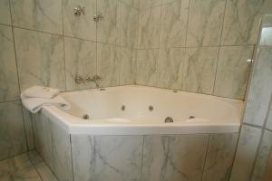 a white bath tub in a bathroom with marble walls at The Lodge on Elizabeth Boutique Hotel in Hobart
