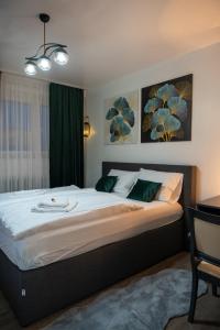 a bedroom with a large bed with green pillows at APARTMAN POZORISTE Penthaus in Banja Luka