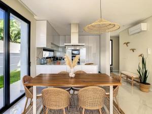 a kitchen and dining room with a wooden table and chairs at Noah - Private Sunset Hideaway by LovelyStay in Arco da Calheta