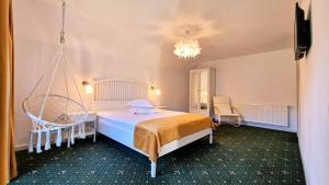 a bedroom with a bed and two chairs at Colț Viu Deluxe in Şimon +34 photos