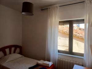 um quarto com uma cama e uma janela com cortinas brancas em Casa rural Las Peñas em Saucelle