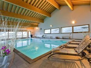 una gran piscina con 2 tumbonas junto a ella en Appartement Orelle, domaine Les 3 vallées / Val Thorens, en Orelle