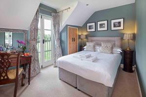 a bedroom with a bed and a desk and a window at Hill Farm in Oxford