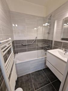 a bathroom with a bath tub and a sink at Bulle enchantée entre lac et montagne in Allevard