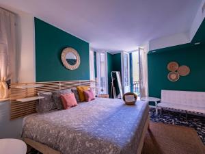 una camera con un grande letto e una parete verde di Mahamo Suites a Verona