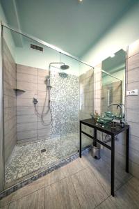 La salle de bains est pourvue d'une douche, d'un lavabo et d'une table. dans l'établissement Mahamo Suites, à Vérone