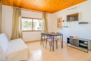 uma sala de estar com uma mesa e cadeiras e um sofá em Bettina & Birgitta - Formentera Break em Es Pujols