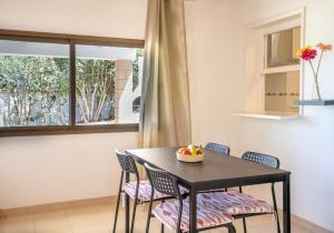 uma sala de jantar com uma mesa e cadeiras e uma janela em Bettina & Birgitta - Formentera Break em Es Pujols