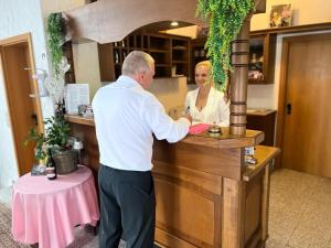 a man standing at a counter with a woman behind it at Schozacher Stüble in Talheim