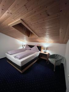 a bedroom with a large bed and a chair at Appartement Bichl in Sölden