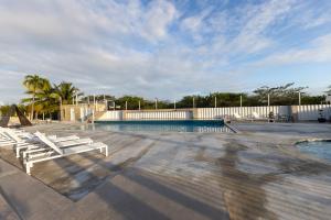 a swimming pool with white lounge chairs next to it at BOHO Beach Club in Boqueron