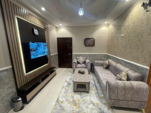 a living room with a couch and a flat screen tv at Admire Apart' Hotel - Jeddah in Jeddah