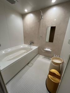 a bathroom with a tub and a toilet and a sink at 旭川ホテル818-大人専用 in Asahikawa