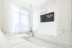 ein weißes Wohnzimmer mit einem weißen Sofa und einem TV in der Unterkunft 10353 Residential complex Central Park cozy apartment in Kiew