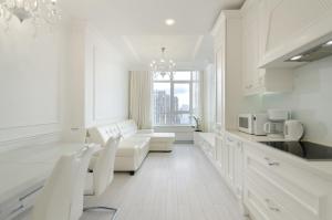 ein weißes Wohnzimmer mit einem Sofa und einer Küche in der Unterkunft 10353 Residential complex Central Park cozy apartment in Kiew