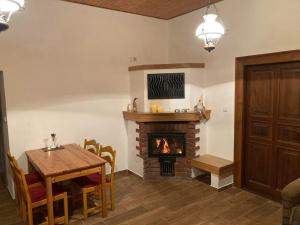 a dining room with a fireplace and a table and a table and chairs at U potoka Cedronu in Jilemnice
