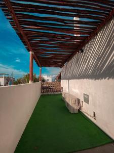 un patio en la azotea con sillas y un suelo verde en Hotel Maya Jade, en Monterrico