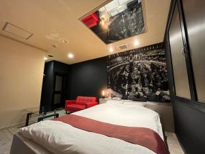 ein Schlafzimmer mit einem großen Bett und einem roten Stuhl in der Unterkunft 旭川ホテル818-大人専用 in Asahikawa