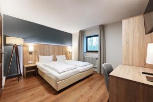 慕尼黑的住宿－Hotel Schleuse，配有一张床和一张书桌的酒店客房