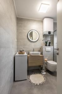a bathroom with a sink and a toilet and a mirror at Mala Kate Apartments in Kaštela