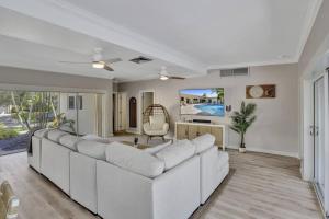 ein Wohnzimmer mit einem weißen Sofa und einem Tisch in der Unterkunft Brand New! Heated Pool, Golf Cart, Next to Beach in Fort Lauderdale
