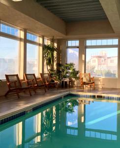 a house with a swimming pool with chairs and windows at Atlantic Beach Hotel Newport in Middletown