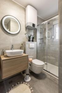 W łazience znajduje się umywalka, toaleta i prysznic. w obiekcie Mala Kate Apartments w mieście Kaštela