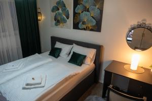 a bedroom with a bed with a table and a mirror at APARTMAN POZORISTE Penthaus in Banja Luka