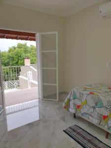 - une chambre avec un lit et une porte coulissante en verre dans l'établissement Casa ChaCha - Paz e Bem, à Águas de São Pedro