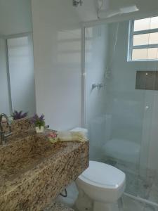 a bathroom with a white toilet and a shower at Casa ChaCha - Paz e Bem in Águas de São Pedro