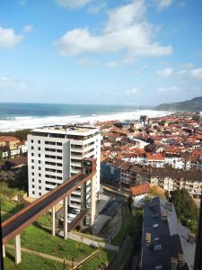 Vistas a una ciudad con un edificio blanco y al océano en SARAKATUA15 vistas espectaculares - familias y parejas - 2 dormitorios independientes - amplio salón cocina comedor - tarjeta parking OTA GRATIS zona azul y residentes - Estancia mínima 2 noches - julio y agosto de domingo a domingo 7 noches -, en Zarautz