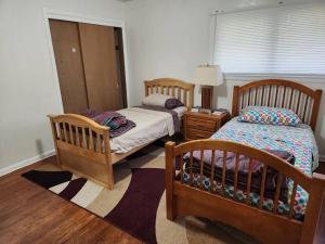 a bedroom with two beds and a table with a lamp at Spacious 4-bedroom home in quiet neighborhood in Milwaukee