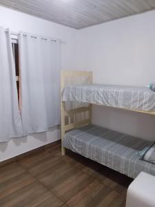 two bunk beds in a room with a window at Pousada Porto do Torquato in Florianópolis