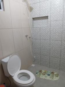 a white bathroom with a toilet and a shower at Pousada Porto do Torquato in Florianópolis