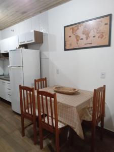 a kitchen with a table and chairs and a refrigerator at Pousada Porto do Torquato in Florianópolis