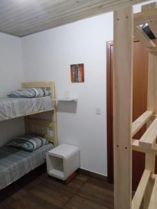 a dorm room with two bunk beds and a desk at Pousada Porto do Torquato in Florianópolis
