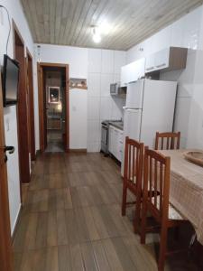 a small kitchen with a table and a refrigerator at Pousada Porto do Torquato in Florianópolis