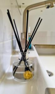 a glass vase with sticks in it on a counter at Huisje 11 Wemeldinge in Wemeldinge +41 photos
