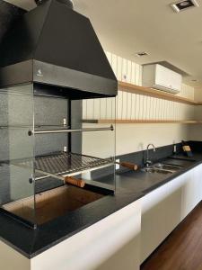 una cocina con encimera negra y fregadero en Studio Brava Holiday, en Florianópolis