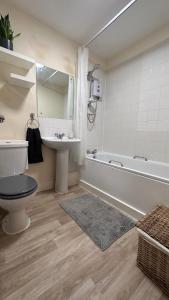 a bathroom with a toilet and a sink and a tub at Central London spacious Studio in London