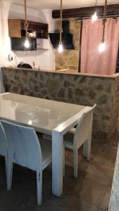 a white table and two chairs in front of a counter at Mirador de Garciez in Torre del Campo