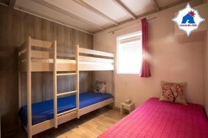 a bedroom with two bunk beds and a window at Costa do Vizir Beach Village in Porto Covo