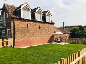 a brick house with a fence in a yard at Grove Farm Loft Annexe Includes Continental Breakfast in Lincoln