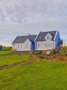 a house in a field with green grass at Self catering upstairs apartment at Tradcottage in Sligo