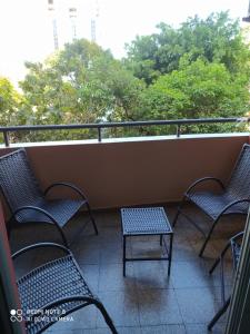 três cadeiras e uma mesa numa varanda em Amplio y cómodo apartamento con bella vista en pleno centro em Ciudad del Este
