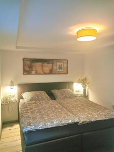 1 dormitorio con 1 cama en una habitación con 2 lámparas en Möwenstübchen, en Zingst