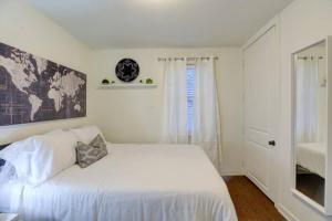 um quarto branco com uma cama branca e uma janela em Private Gated Cottage Walk to Overton Square em Memphis