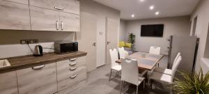 a kitchen and dining room with a table and chairs at Hős-Ceglédi Vendégház Miskolc -Önálló otthon, mely csak az Önöké in Miskolc